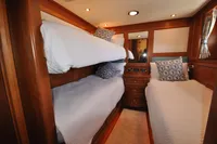 Luxurious 2010 Trader 64 Sunliner cabin with cozy bunk beds and elegant wood finish.