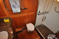 Luxurious bathroom in 2010 Trader 64 Sunliner yacht with wood paneling and glass shower.