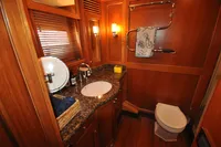Luxurious wooden bathroom interior in 2010 Trader 64 Sunliner yacht, featuring elegant fixtures and decor.