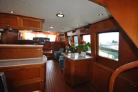 Luxurious interior of 2010 Trader 64 Sunliner yacht with wooden finishes and potted plants.