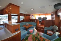 Luxurious interior of 2010 Trader 64 Sunliner yacht with elegant wood and blue seating.