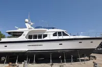 2010 Trader 64 Sunliner yacht on dry dock under clear blue sky.