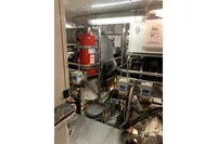 Engine room of 2010 Trader 64 Sunliner yacht with equipment and fire extinguisher.