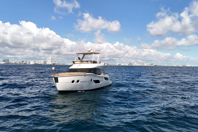  Yacht Photos Pics 2014 Carver 40 Command Bridge yacht on open sea with city skyline backdrop.