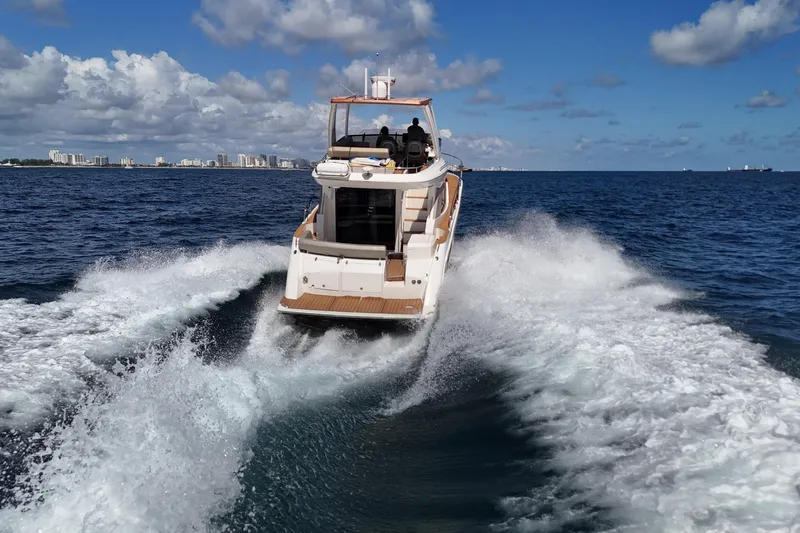  Yacht Photos Pics 2014 Carver 40 Command Bridge cruising on open water, city skyline in background.