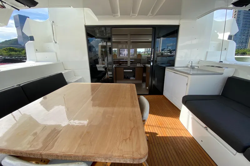  Yacht Photos Pics Spacious deck of 2022 Lagoon 50 yacht with dining area and kitchenette.