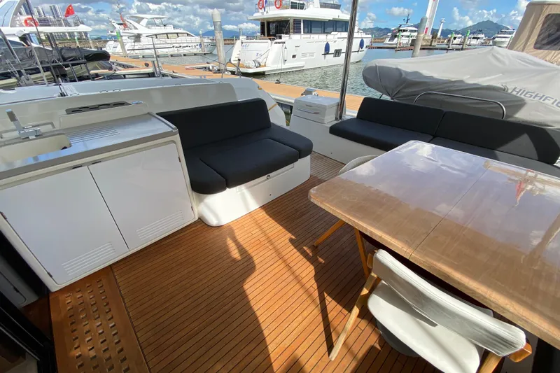  Yacht Photos Pics Luxurious 2022 Lagoon 50 yacht deck with seating, table, and marina view.
