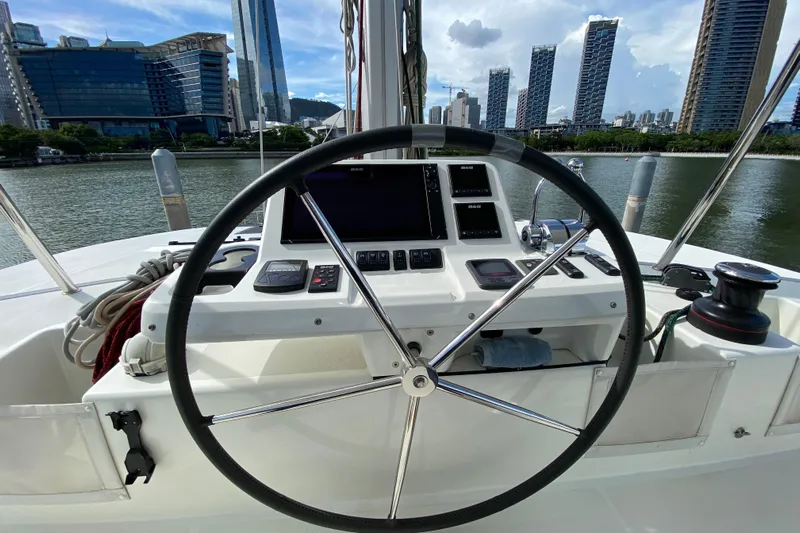 Yacht Photos Pics Helm of 2022 Lagoon 50 catamaran with city skyline in background.