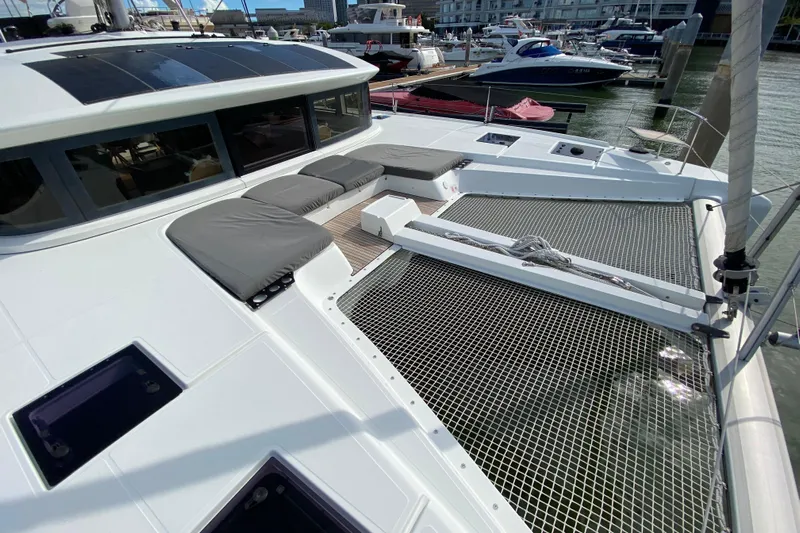  Yacht Photos Pics 2022 Lagoon 50 catamaran with spacious deck and netting, docked in a marina.