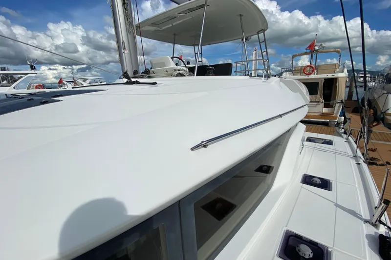 Yacht Photos Pics 2022 Lagoon 50 catamaran docked at marina under cloudy sky.