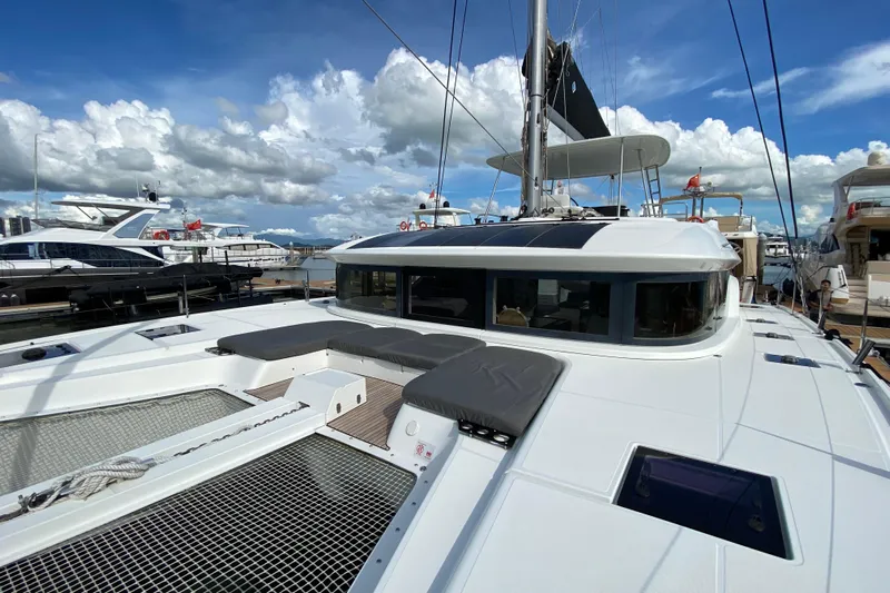  Yacht Photos Pics 2022 Lagoon 50 catamaran docked, showcasing sleek design and spacious deck under a blue sky.