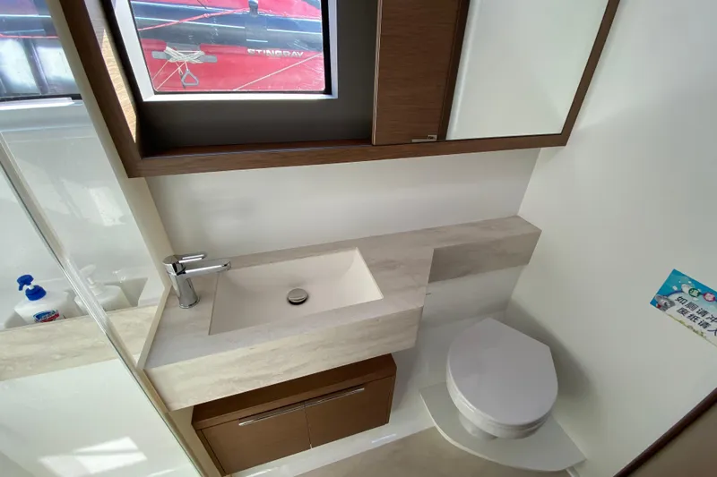  Yacht Photos Pics Modern bathroom in 2022 Lagoon 50 yacht with sink, toilet, and window.