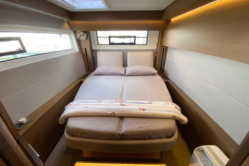  Yacht Photos Pics Luxurious bedroom interior of 2022 Lagoon 50 yacht with modern design and cozy bedding.