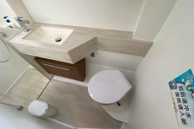  Yacht Photos Pics Modern bathroom in 2022 Lagoon 50 yacht with sink, toilet, and shower area.