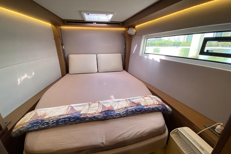  Yacht Photos Pics Luxurious cabin interior of 2022 Lagoon 50 yacht with cozy bed and window view.