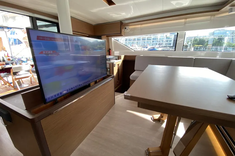  Yacht Photos Pics Interior of 2022 Lagoon 50 yacht with modern TV and dining area.