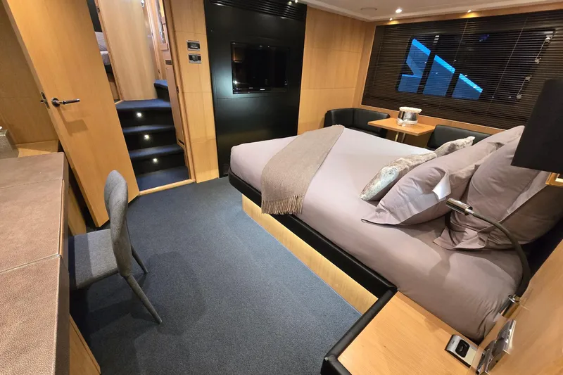  Yacht Photos Pics Luxurious bedroom interior of 2011 Princess 72 yacht with modern furnishings and cozy ambiance.