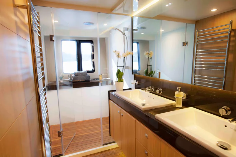  Yacht Photos Pics Luxurious yacht bathroom with dual sinks, glass shower, and elegant wood accents.