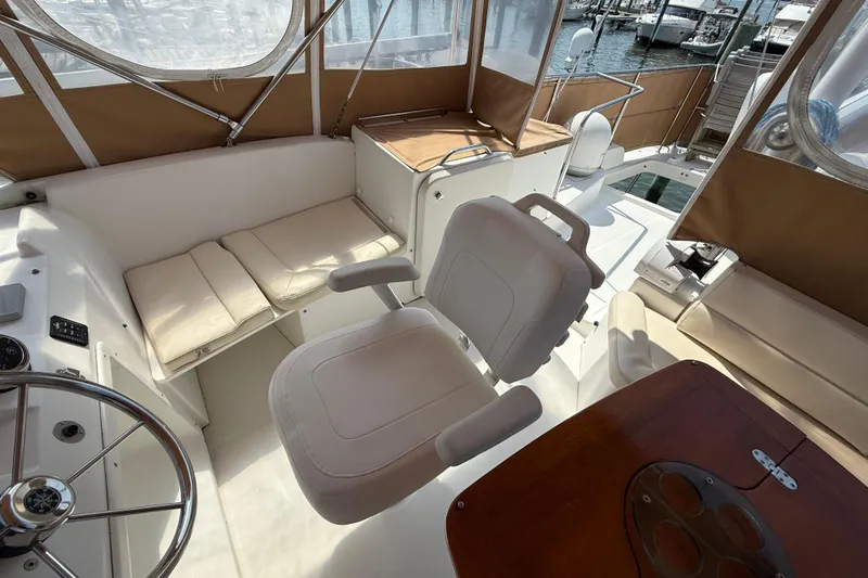 All At Sea Yacht Photos Pics 2007 Beneteau Swift Trawler 42 interior with helm, seating, and wooden table.