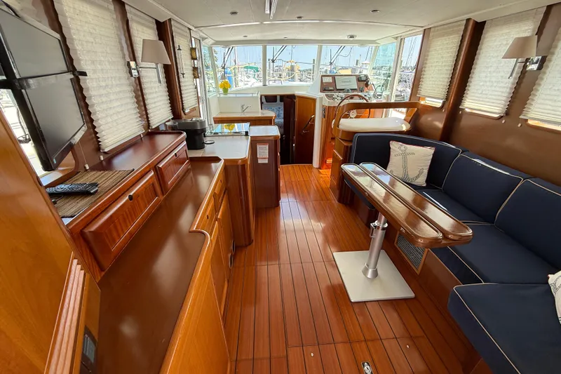 All At Sea Yacht Photos Pics Interior of 2007 Beneteau Swift Trawler 42 with wood finish and blue seating.