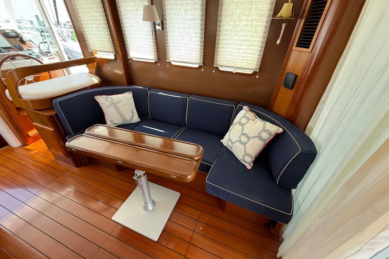 All At Sea Yacht Photos Pics Luxurious interior of 2007 Beneteau Swift Trawler 42 with navy seating and wooden table.