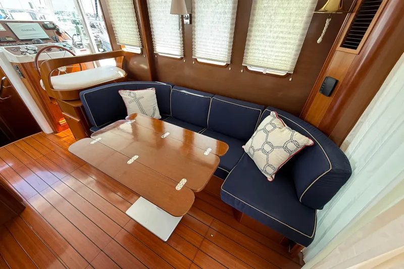 All At Sea Yacht Photos Pics Interior of 2007 Beneteau Swift Trawler 42 with wooden flooring and navy seating.