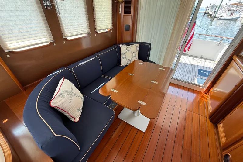 All At Sea Yacht Photos Pics Interior of 2007 Beneteau Swift Trawler 42 with wooden flooring and navy seating.