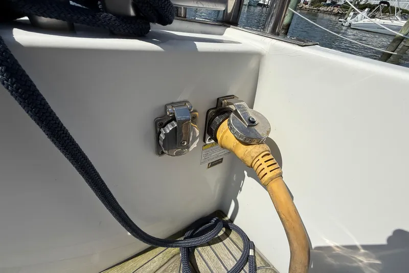 All At Sea Yacht Photos Pics Power connection on a 2007 Beneteau Swift Trawler 42 boat, docked with visible ropes.