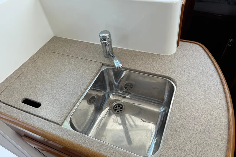 All At Sea Yacht Photos Pics Kitchen sink area in 2007 Beneteau Swift Trawler 42, featuring stainless steel sink and faucet.
