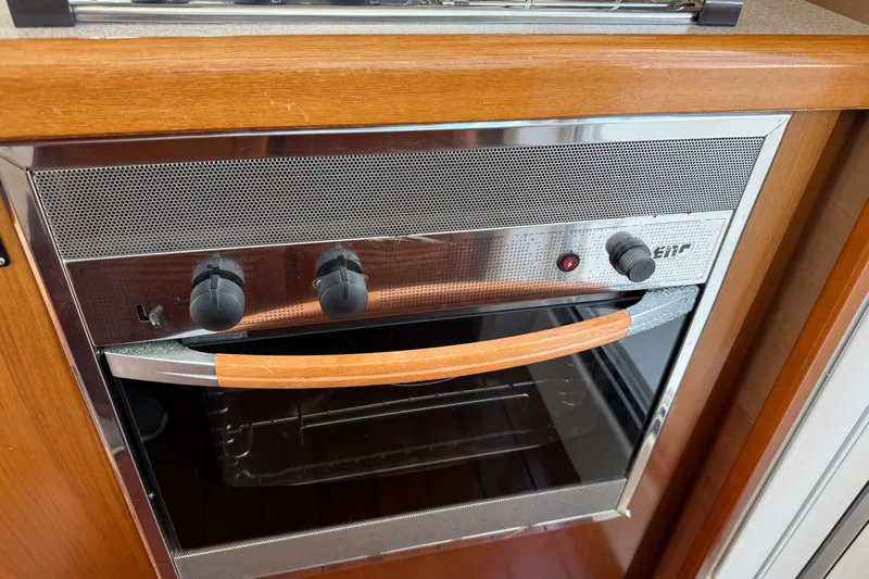 All At Sea Yacht Photos Pics Stainless steel oven in 2007 Beneteau Swift Trawler 42, featuring wooden handle and control knobs.