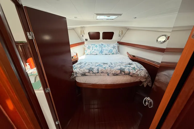 All At Sea Yacht Photos Pics 2007 Beneteau Swift Trawler 42 cabin with cozy bed and elegant wood finish.