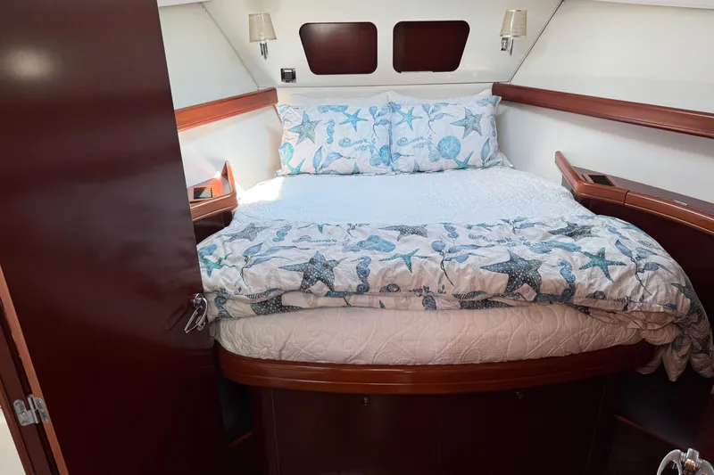 All At Sea Yacht Photos Pics Cozy bedroom in 2007 Beneteau Swift Trawler 42 with nautical-themed bedding.