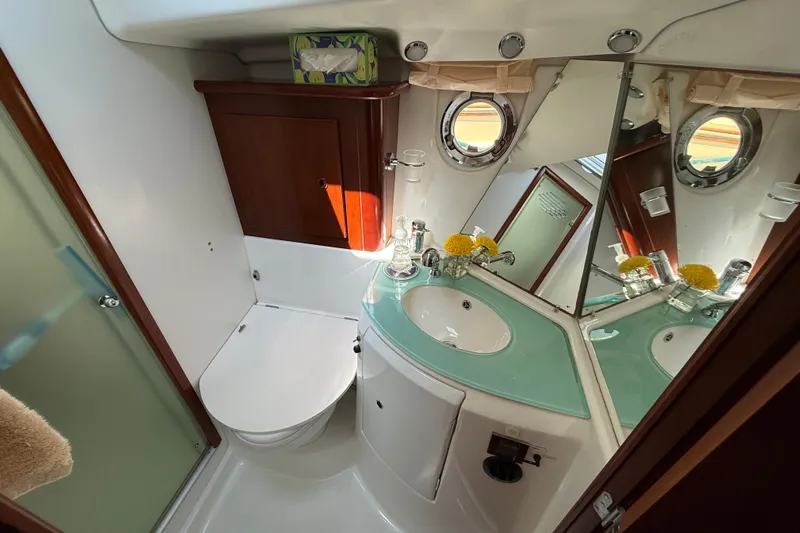 All At Sea Yacht Photos Pics Bathroom interior of 2007 Beneteau Swift Trawler 42 with modern fixtures and porthole window.