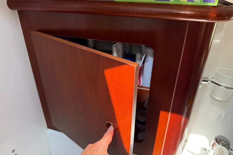 All At Sea Yacht Photos Pics Wooden cabinet door on 2007 Beneteau Swift Trawler 42, partially open with visible contents.