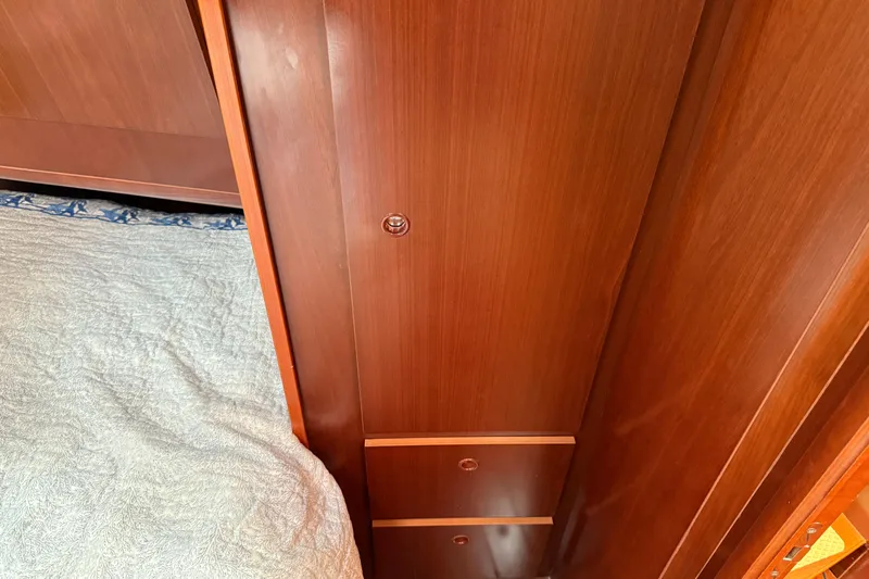 All At Sea Yacht Photos Pics Wooden interior of 2007 Beneteau Swift Trawler 42, featuring a bed and storage.