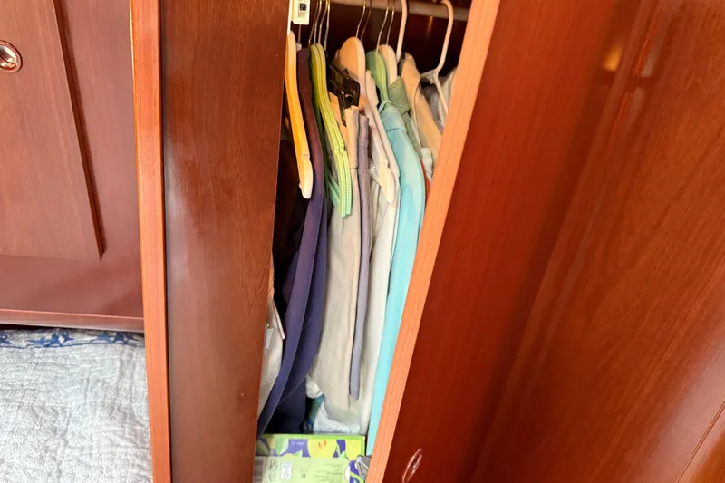All At Sea Yacht Photos Pics Wooden closet with hanging clothes inside a 2007 Beneteau Swift Trawler 42.