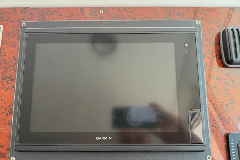 All At Sea Yacht Photos Pics Garmin display on 2007 Beneteau Swift Trawler 42 dashboard with wood paneling.