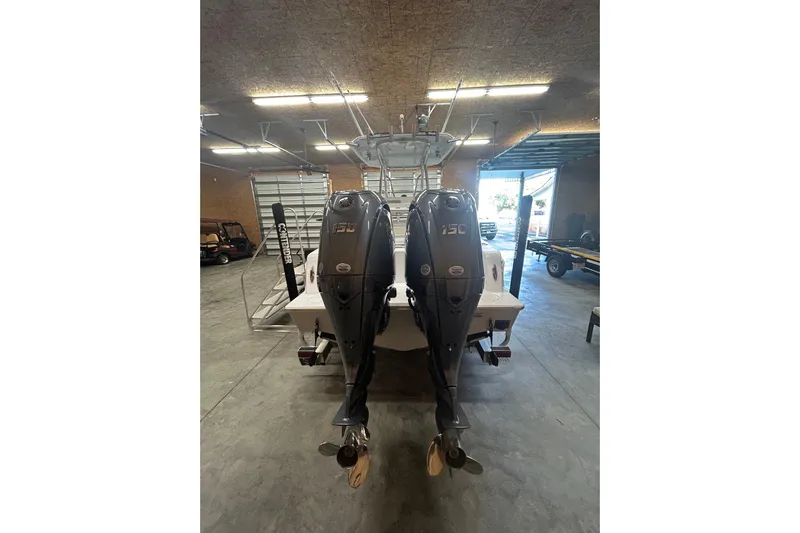  Yacht Photos Pics 2024 Contender 24 Sport boat with dual 150 horsepower engines in a garage.