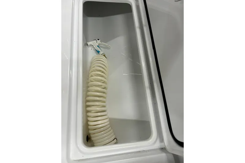  Yacht Photos Pics Coiled hose in storage compartment of 2024 Contender 24 Sport boat.