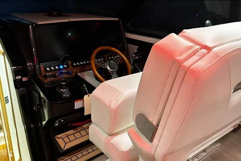 Only 113 Hours Yacht Photos Pics 2023 Tiara Yachts 43 LS helm with white seating and wooden steering wheel.