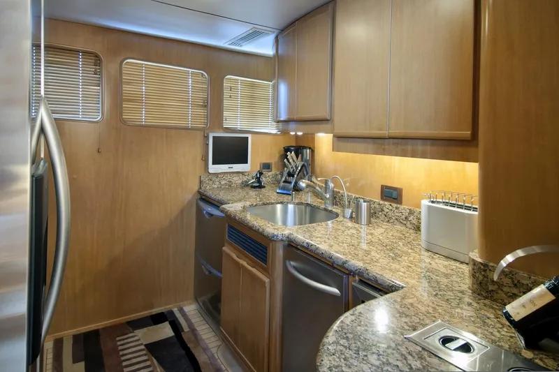 Compass Rose Yacht Photos Pics Compact kitchen in a 1995 Custom Heisley, featuring granite countertops and modern appliances.