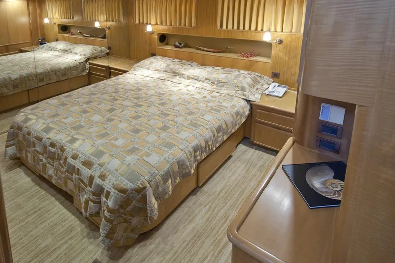 Compass Rose Yacht Photos Pics Luxurious 1995 Custom Heisley bedroom with elegant wood paneling and cozy bedding.