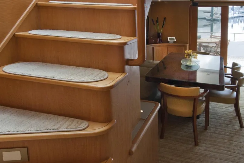 Compass Rose Yacht Photos Pics Luxurious yacht interior with wooden stairs and elegant dining area, Custom Heisley 1995 model.