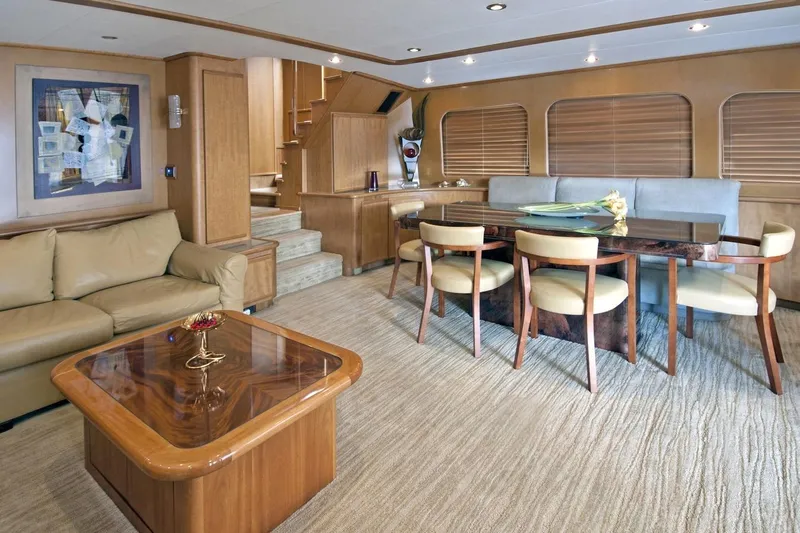 Compass Rose Yacht Photos Pics Luxurious yacht interior with elegant dining area, beige sofa, and modern art, Custom Heisley 1995.