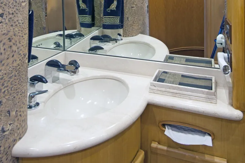 Compass Rose Yacht Photos Pics Luxurious bathroom with marble sink, mirrored backsplash, and elegant decor in a 1995 Custom Heisley model.