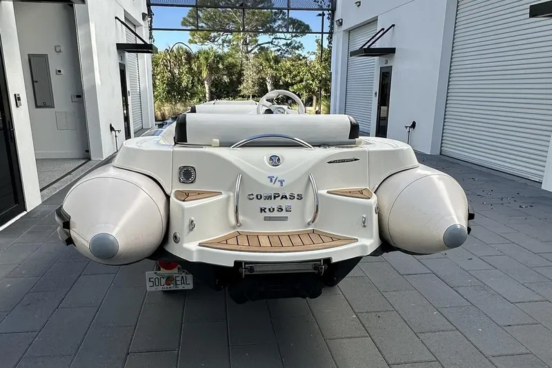 Compass Rose Yacht Photos Pics Custom 1995 Heisley boat named "Compass Rose" parked near modern garage.