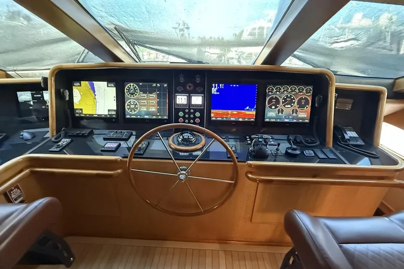 Compass Rose Yacht Photos Pics Heisley Flybridge 1995 yacht cockpit with navigation screens and steering wheel.