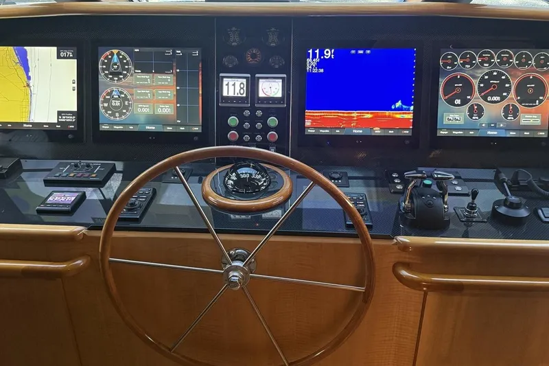 Compass Rose Yacht Photos Pics Helm of 1995 Heisley Flybridge yacht with navigation screens and controls.
