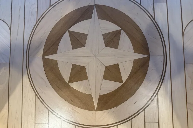 Compass Rose Yacht Photos Pics Intricate wooden star inlay on Heisley Flybridge 1995 yacht floor.