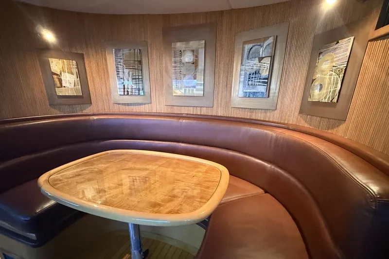 Compass Rose Yacht Photos Pics Luxurious 1995 Heisley Flybridge interior with curved leather seating and modern art decor.